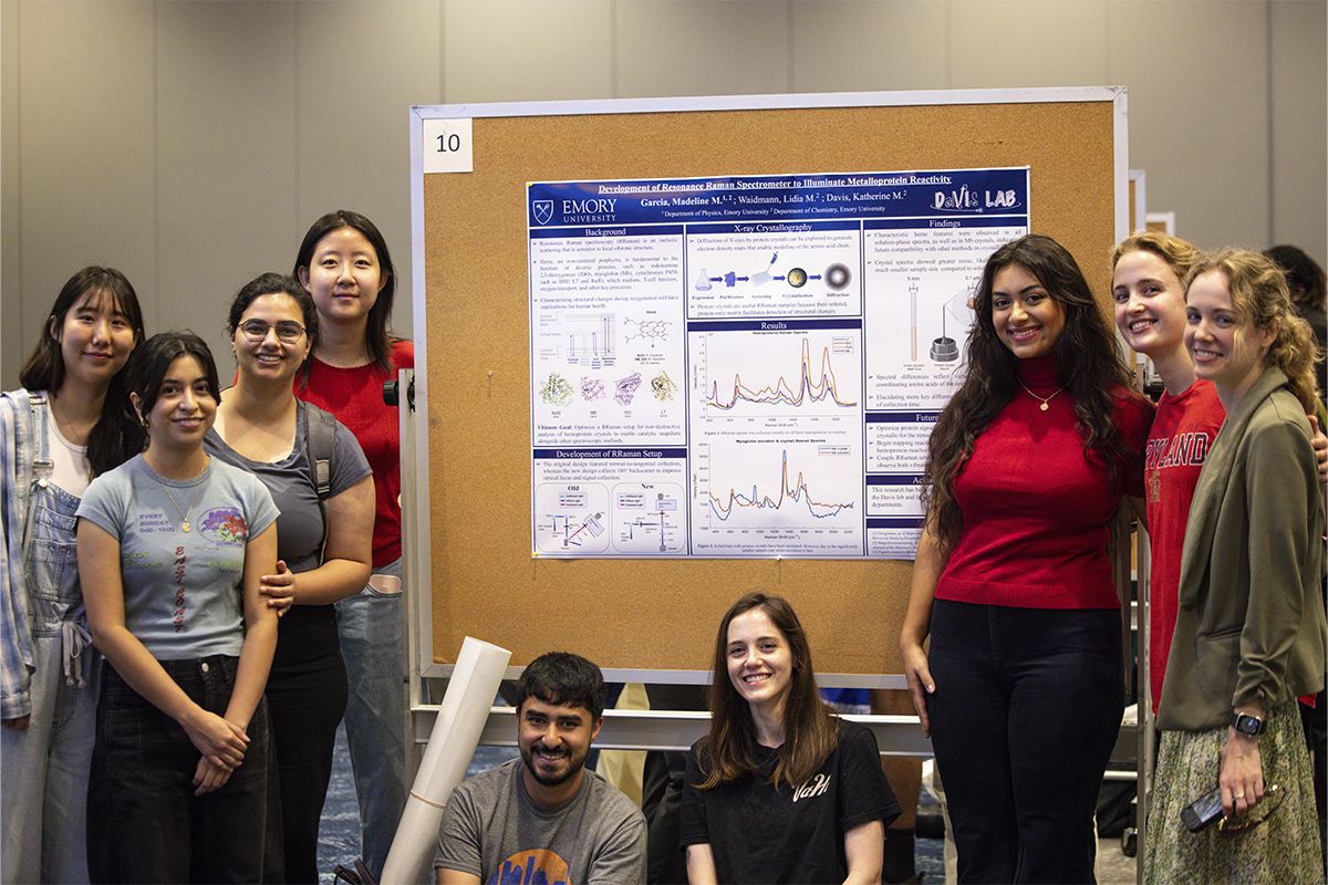 students standing in front of research presentation board